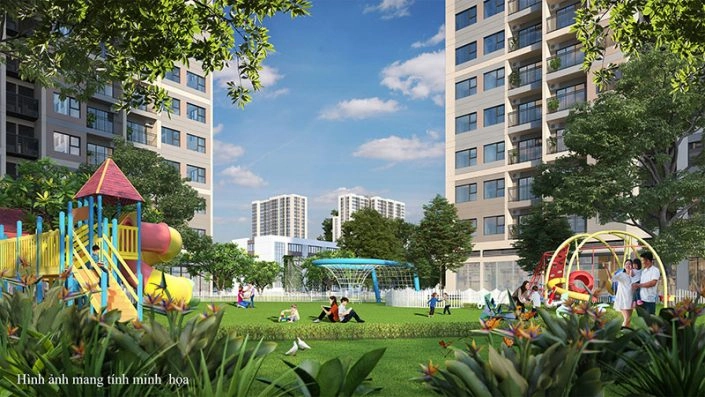 Góc nhìn từ công viên với khu vui chơi trẻ em đầy màu sắc, cây xanh bao quanh và các tòa nhà chung cư phía sau.