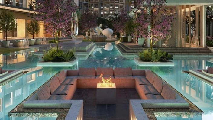 Khu vực lounge ngoài trời sang trọng với hồ bơi, ghế sofa và hố lửa trung tâm