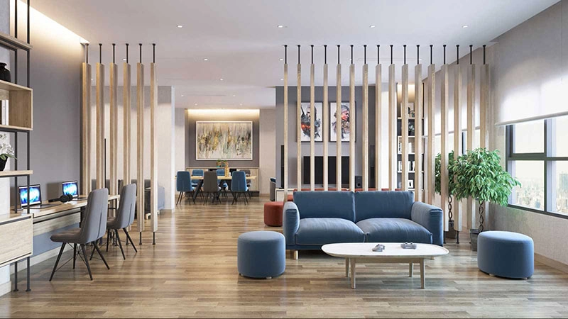 Không gian phòng khách chung hoặc lounge với sofa màu xanh, bàn làm việc, vách ngăn gỗ và khu vực ăn uống