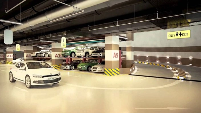Hầm đỗ xe hiện đại và rộng rãi với nhiều ô tô đang đỗ và lối đi lên/xuống rõ ràng.